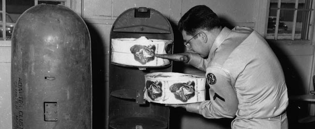 Rolls of anti-communist propaganda leaflets are loaded into an M.29 cluster bomb for dropping over northern Korea.