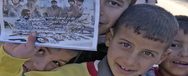 Young Iraqi boys hold a voting flyer.